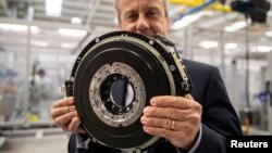 Chris Harris, a CEO of YASA, holds a 24kg (53lbs) axial-flux electric motor for a high-performance electric car as he poses for a photo at the company's headquarters and production facility in Oxford, Britain, August 24, 2021. (REUTERS/May James)