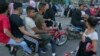 Une fille harcelée dans la rue par un groupe de jeunes hommes sur des motos, à Gizeh, en Égypte, le 15 juin 2018 (Hamada Elrasam/VOA)