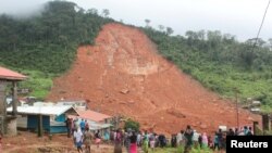 Moun kap kade dega lapli ak gwo inondasyon koze nan mòn ki nan zòn site Regent la nan Sierra Leone. 14 out 2017. Foto: REUTERS/Ernest Henry. 