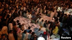 Para anggota keluarga dan kerabat berkumpul di dekat jenazah korban serangan bom di Lahore, Pakistan (2/11).