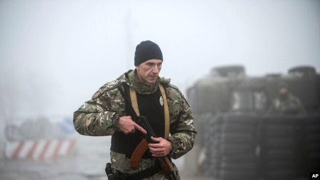乌克兰东部亚速海南岸的伯德扬斯克，一名乌克兰警察在检查站附近巡逻。周一，乌克兰议会通过了总统提出的一项30天戒严令的动议。（2018年11月27日）