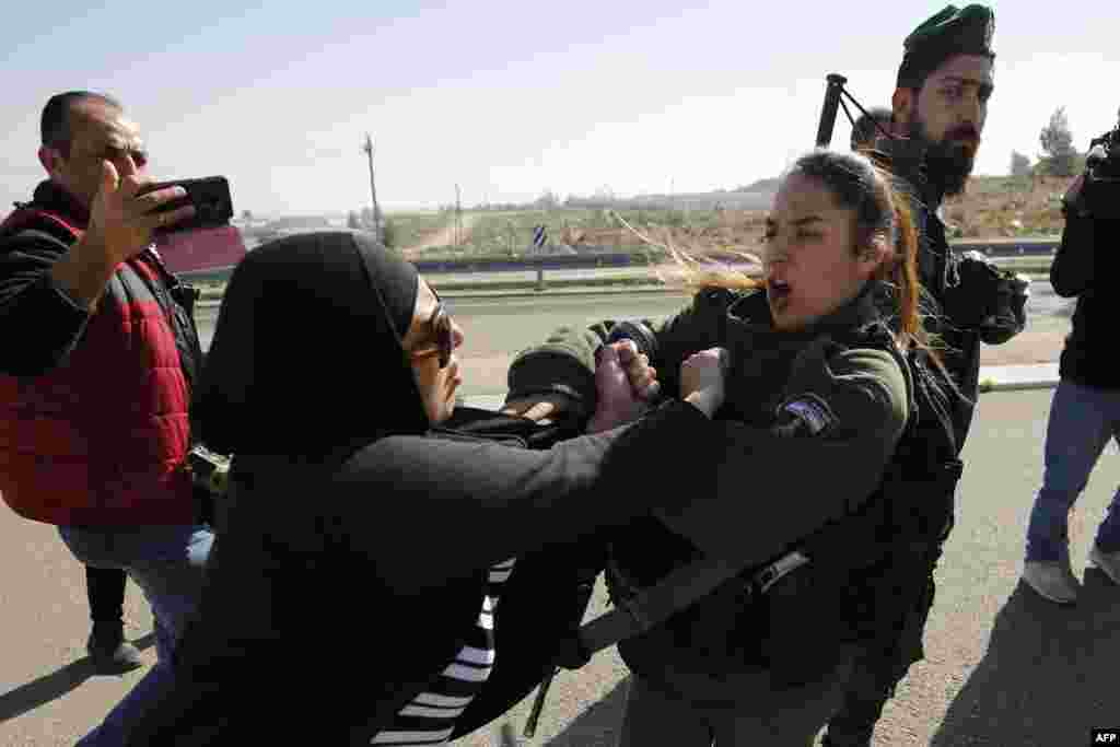 Seorang demonstran perempuan Palestina bentrok dengan seorang penjaga perbatasan Israel dalam sebuah demonstrasi menentang Rute 4370 yang baru dibuka di wilayah pendudukan Tepi Barat.