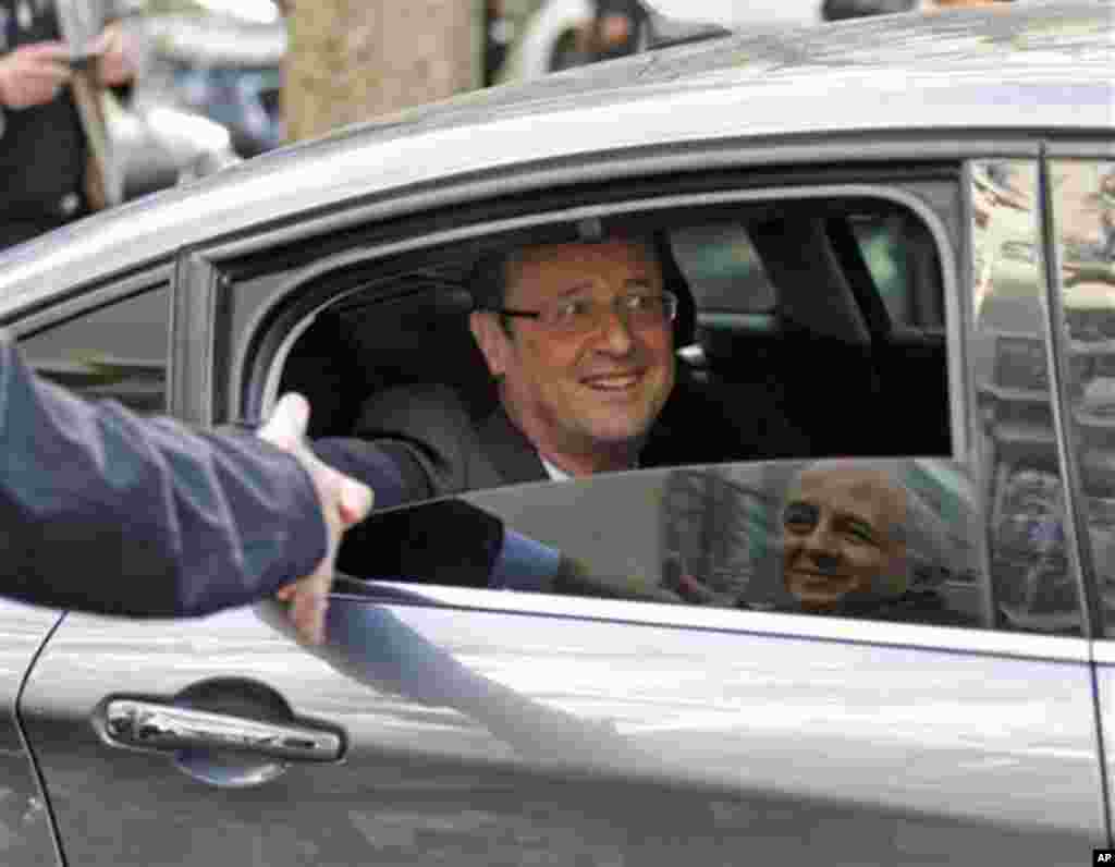 President-elect Francois Hollande shakes hand with supporters as he leaves his campaign headquarters in Paris, Wednesday May 10, 2012. After winning the French Presidential Election, Hollande seems set to embark on a whir-wind introduction to internation