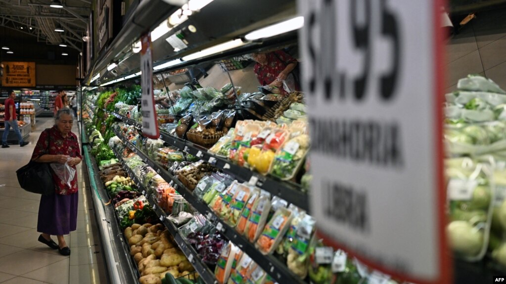 Una mujer camina junto a la sección de verduras en un supermercado privado en San Salvador el 8 de julio de 2024. 