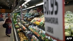 Una mujer camina junto a la sección de verduras en un supermercado privado en San Salvador el 8 de julio de 2024. 