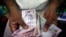 FILE - A private money trader counts Indian rupee currency notes at a shop in Mumbai, India.