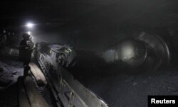 FILE - Miners work in a Komsomolskaya coal mine about 1,080 meters (3,543 feet) under the surface in the city of Vorkuta, Sept. 2, 2014.