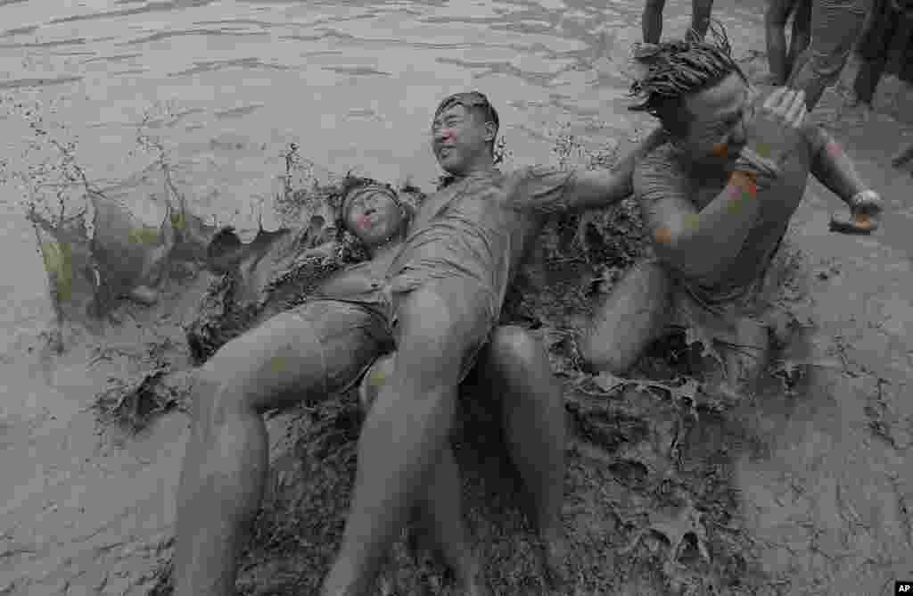 Homens lutam na lama no Festival de Lama de Boryeong na Praia de Daecheon em Boryeong, Coreia do Sul, Sábado, Julho 22, 2017.