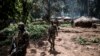 Des soldats des Forces armées de la République démocratique du Congo (FARDC) traversent une base ennemie récemment capturée le long de la ligne de front le 4 juillet 2019 dans la forêt de Wagu, dans l'est de la RDC. (Photo de John WESSELS / AFP)