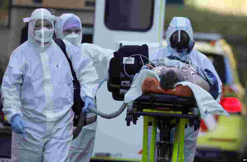 Healthcare workers move a COVID-19 patient to the Motol hospital in Prague, Czech Republic, Friday, Nov. 6, 2020. The hospital in Prague has admitted five patients in serious condition from hospitals that were overrun due to the coronavirus pandemic. (AP 