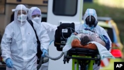 Zdravstveni radnici premeštaju pacijenta obolelog od koronavirusa u bolnici u Pragu, (Foto: AP/Petr David Josek)