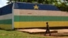 FILE - A man walks in front of the jail of Bangui, "Maison Centrale de Ngaragba," whose walls are painted with the colors of the flag of Central African Republic, April 22, 2014. 