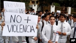 A student holds up a sign reading "no more violence" in Spanish, during a protest against presidential re-election, in Asuncion, Paraguay, April 3, 2017.