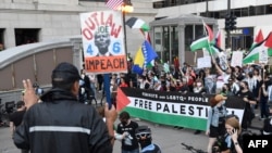 Para pengunjuk rasa mengibarkan bendera Palestina selama aksi protes untuk menuntut gencatan senjata di Gaza pada malam menjelang Konvensi Nasional Demokrat (DNC) di United Center di Chicago, Illinois, AS. 