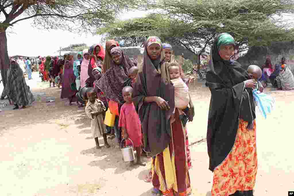 Women stand in line with pots to collect rice at Badbaado IDP camp in Mogadishu, Somalia, August 11, 2011. (VOA - P. Heinlein)