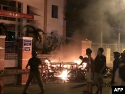 Picture taken on June 10, 2018 shows protesters burning motorcycles in front of a provincial office in Vietnam's south central coast Binh Thuan province in response to legislation on three special economic zones that would grant 99-year leases to companie