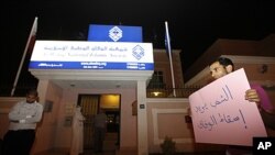 A Bahraini Shi'ite protester holds a sign outside the headquarters of Wefaq, the leading Shi'ite opposition group, in Manama, July 1, 2011