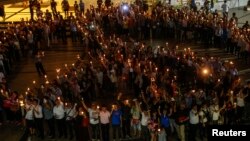 Warga memegang lilin sambil membentuk tanda Peace (damai) dalam sebuah kampanye anti-kekerasan di pusat kota Bangkok (3/1/2014).