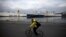 A man rides his bicycle at the port of Piraeus, near Athens, Greece, Feb. 4, 2016. Greek dockworkers began a two-day strike on Feb. 16, 2016, to protest against the sale of the country's two biggest ports, which Athens has promised to international lenders, disrupting operations at cargo terminals.