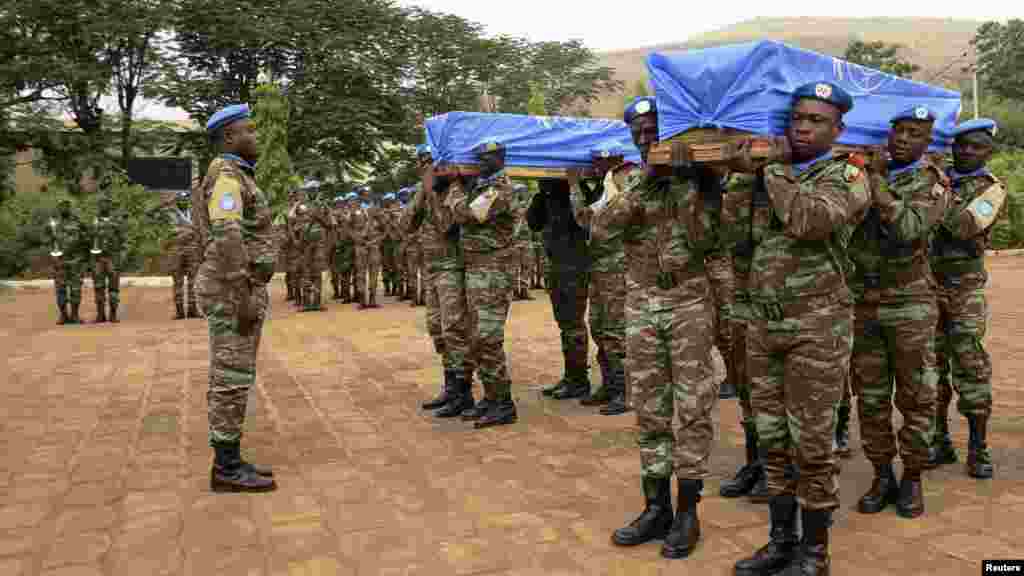 Des Casques bleus de la MINUSMA portent les cercueils des deux soldats sénégalais tués dans l'attentat perpétré à Kidal, Bamako, le 18 décembre 2013.