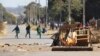 FILE: School children run past a burning barricade, following a job boycott called via social media platforms, in Harare, Wednesday, July,6, 2016