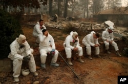 Members of the California Army National Guard take a break at they search burned homes for human remains at the Camp Fire, Nov. 15, 2018, in Paradise, Calif.