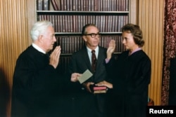 FILE - Sandra Day O'Connor, kanan, dilantik sebagai Hakim Agung oleh Ketua Hakim Warren Burger, di Washington, D.C., disaksikan suaminya, John O'Connor, 25 September 1981.