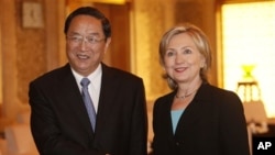 U.S. Secretary of State Hillary Rodham Clinton, right, and Shanghai Party Secretary Yu Zhengsheng shake hands during their meeting at World Expo site Saturday, May 22, 2010 in Shanghai, China. (AP Photo/Eugene Ho