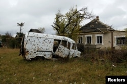 A vehicle damaged by shrapnel and explosions sits abandoned in the Oktyabrsky district in Donetsk, Ukraine, Nov. 1, 2017.