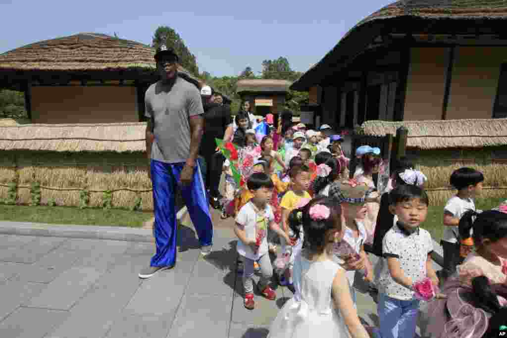 북한을 방문한 데니스 로드먼이 14일 평양의 김일성 생가인 만수대에서 어린이들 옆을 지나고 있다.