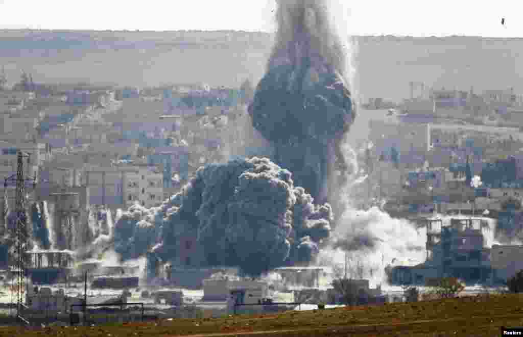 An explosion from an air-strike is seen in the Syrian town of Kobani from the town of Suruc, Turkey, Oct. 29, 2014. 