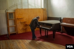 Leonard Houhannisyan, 61, plays piano in a cultural center and music school that was bombed late last week in Nagorno-Karabakh, Oct. 11, 2020. (Yan Boechat/VOA)