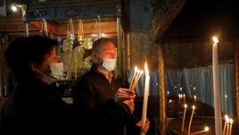Visitors light candles in the Church of the Nativity, amid the coronavirus disease (COVID-19) outbreak, in Bethlehem in the Israeli-occupied West Bank November 26, 2020. (REUTERS/Mussa Qawasma)