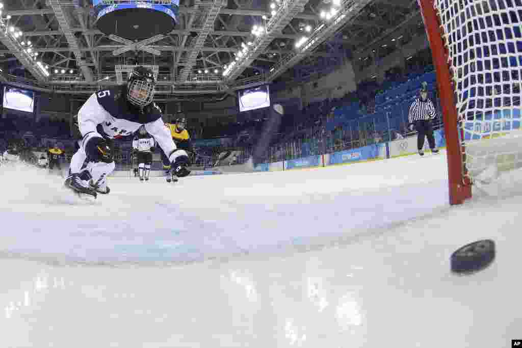 Kanae Aoki of Japan races after the goal shot by Franziska Busch of Germany during the closing seconds of the women's ice hockey game at the 2014 Winter Olympics, Feb. 13, 2014.