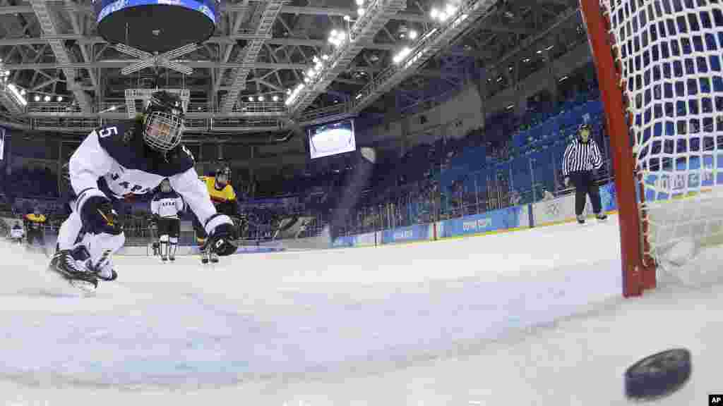 Kanae Aoki of Japan races after the goal shot by Franziska Busch of Germany during the closing seconds of the women's ice hockey game at the 2014 Winter Olympics, Feb. 13, 2014.