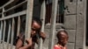 FILE - Children play in front of a bullet-ridden wall of a destroyed store in the village of Bisober, in Ethiopia's Tigray region, Dec. 9, 2020. 