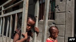 FILE - Children play in front of a bullet-ridden wall of a destroyed store in the village of Bisober, in Ethiopia's Tigray region, Dec. 9, 2020. 