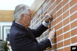 U.S. Secretary of State Rex Tillerson writes a message for soldiers on a brick wall before the lunch meeting at the Camp Bonifas near the border village of Panmunjom, which has separated the two Koreas since the Korean War, in Paju, South Korea, March 17,2017.