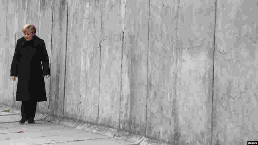 La chancelière allemande Angela Merkel marche le long d'une section de l'ancien mur de Berlin à la mémoire dans la Bernauer Strasse, pendant une cérémonie marquant le 25ème anniversaire de la chute du mur de Berlin, à Berlin, le 9 novembre 2014.