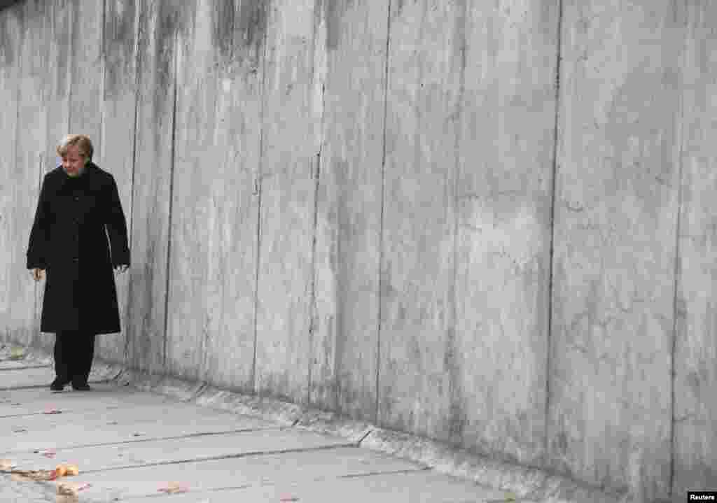 German Chancellor Angela Merkel walks along a section of the former Berlin Wall at the memorial in Bernauer Strasse, during a ceremony marking the 25th anniversary of the fall of the Berlin Wall, in Berlin, Nov. 9, 2014. 