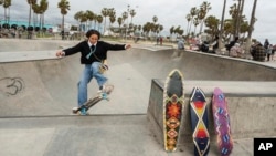 Expert skateboarder Di'Orr Greenwood, an artist born and raised in the Navajo Nation in Arizona and whose work is featured on the new U.S. stamps, exits the concrete bowl in the Venice Beach neighborhood in Los Angeles Monday, March 20, 2023. (AP Photo/Damian Dovarganes)