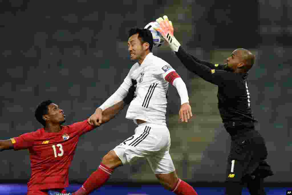 Japan&#39;s Maya Yoshida, center, jumps for the ball as Panama&#39;s goalkeeper Luis Me Jia, right, makes a save and Oscar Linton pushes him during the international friendly soccer game between Japan and Panama at Merkur-Arena stadium in Graz, Austria.