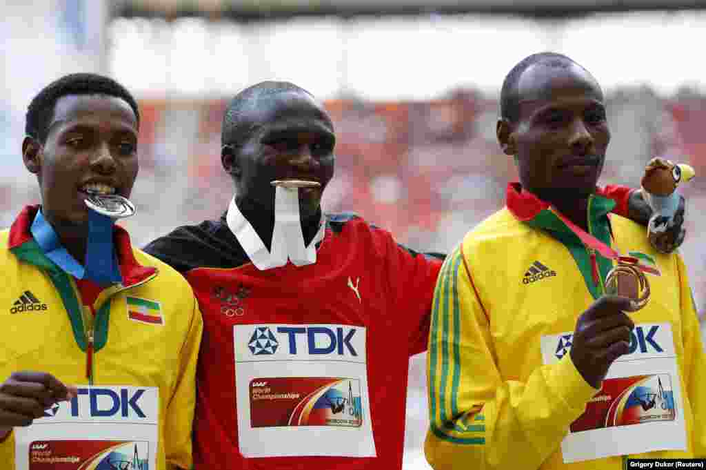 Gold medallist Stephen Kiprotich of Uganda (C) poses with silver medallist Lelisa Desisa of Ethiopia (L) and bronze medallist Tadese Tola of Ethiopia at the men's marathon victory ceremony during the IAAF World Athletics Championships at the Luzhniki stad