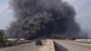 (FILE) Smoke rises while members of the Syrian forces ride on a vehicle as they battle against a nascent insurgency by fighters from ousted leader Bashar al-Assad's Alawite sect, in Latakia, Syria March 7, 2025. 