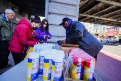 People wear protective masks to fend off the Corona Virus, while street vendors pedal masks, hand sanitizer and other disinfecting products in Queens, New York.