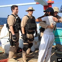 U.S. Navy sailors assigned to the guided-missile destroyer USS Kidd greet a crew member of the Iranian fishing vessel, the Al Molai Friday, Jan. 6, 2012 in the Arabian Sea.