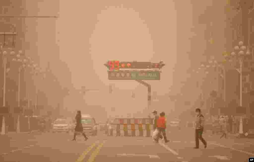 May 12: Residents walk across a junction during a sandstorm in the northern city of Harbin, China. (REUTERS/China Daily)
