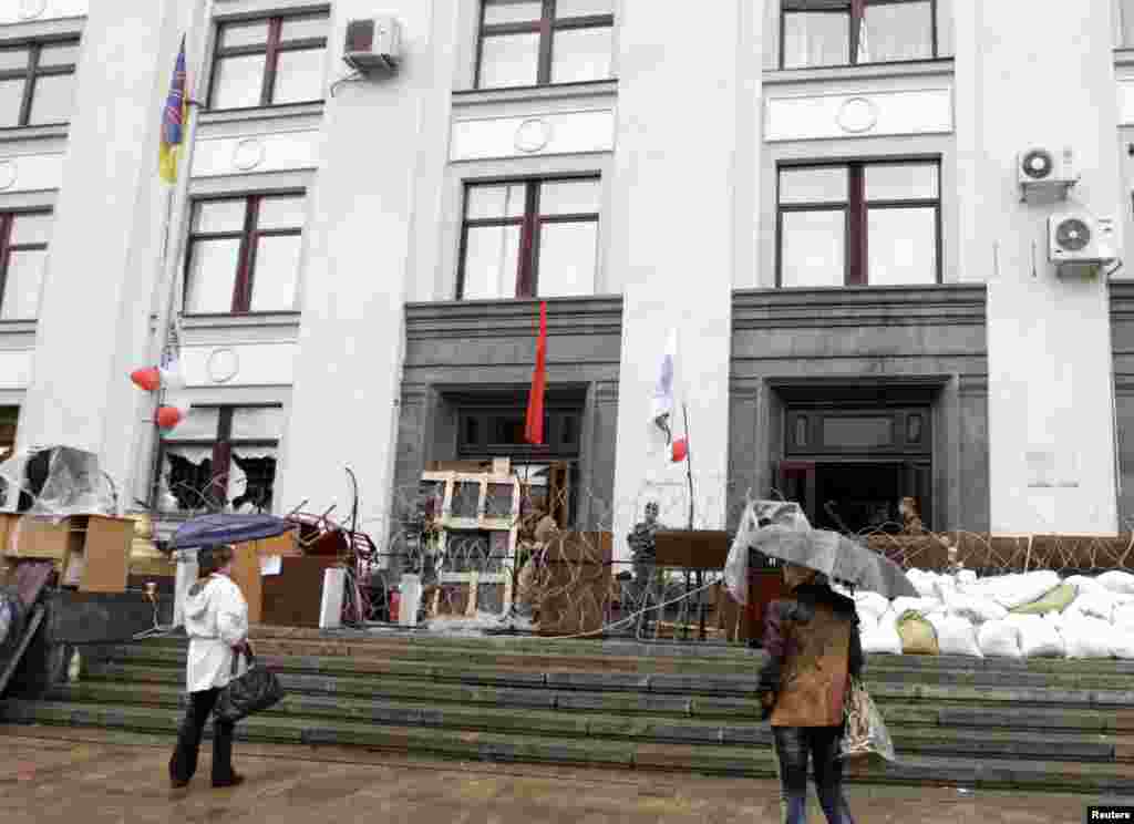 Women stand in front of seized regional government headquarters in Luhansk, eastern Ukraine, May 2, 2014. Ukrainian forces attacked the rebel-held city of Slaviansk before dawn on Friday and pro-Russia separatists shot down at least one attack helicopter,