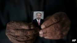 In this Nov. 12, 2017, photo, Ghanim Ahmed holds the photo of his son Ghazwan Ahmed, who was taken by unidentified gunmen.