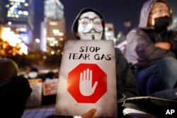 A protester holds a sign reading "Stop Tear Gas" during a rally against the police's use of tear gas in Hong Kong, Friday, Dec. 6, 2019.